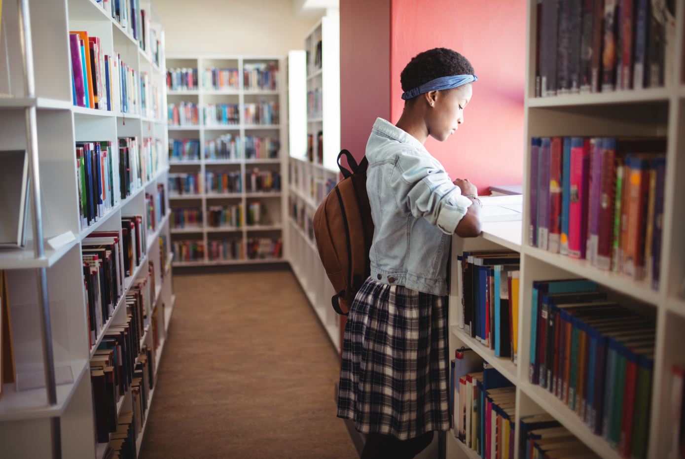 Escola atenciosa lendo livro na biblioteca