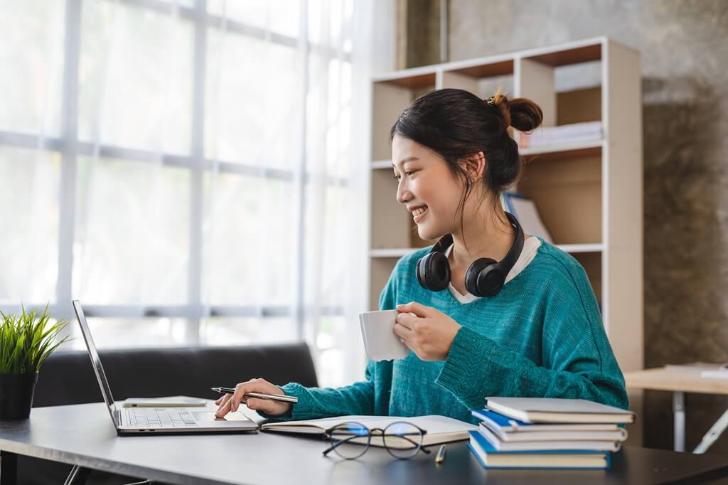 moça estudando com livros e computador