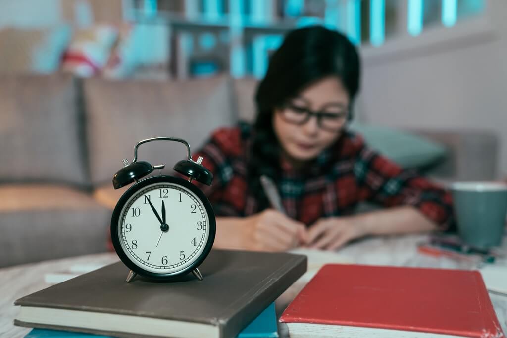 moça estudando com relógio à frente