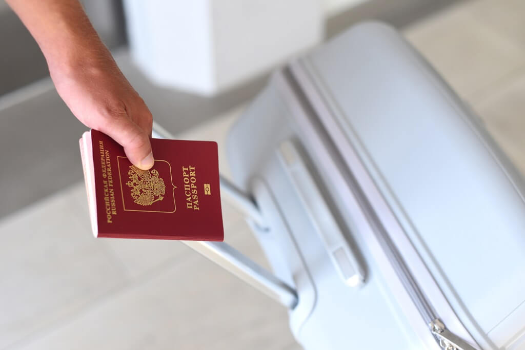 pessoa segurando mala e passaporte