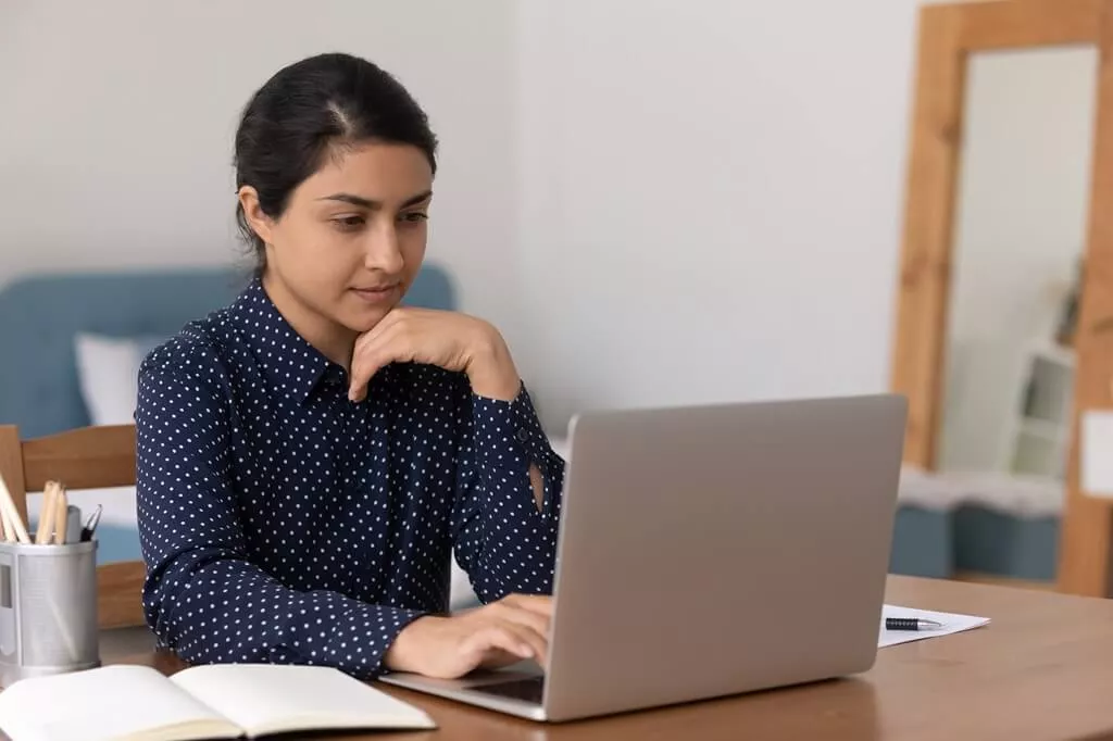 moça olhando concentrada para laptop