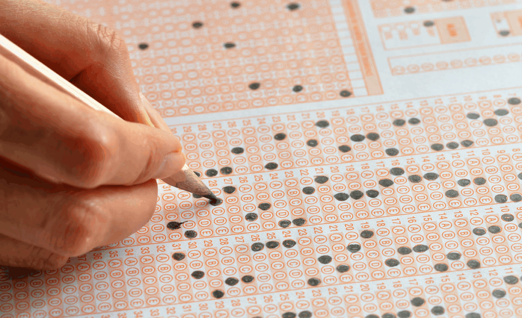 Pessoa preenchendo o gabarito do Enem. Tabela de pontos do Enem.