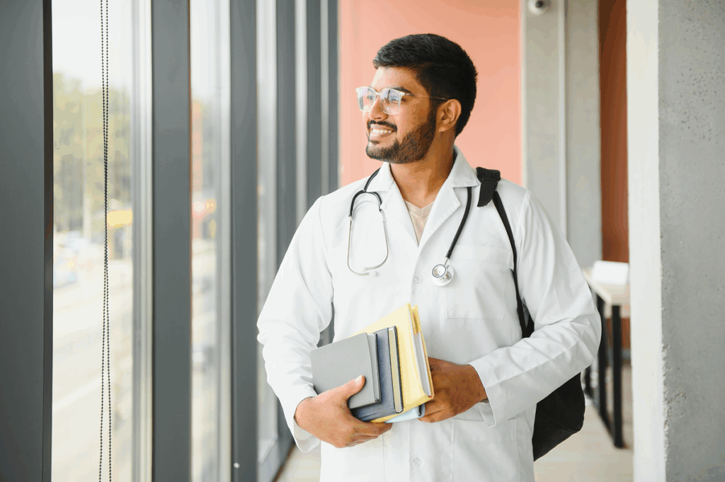 Estudante de medicina de jaleco e carregando livros. UFF.
