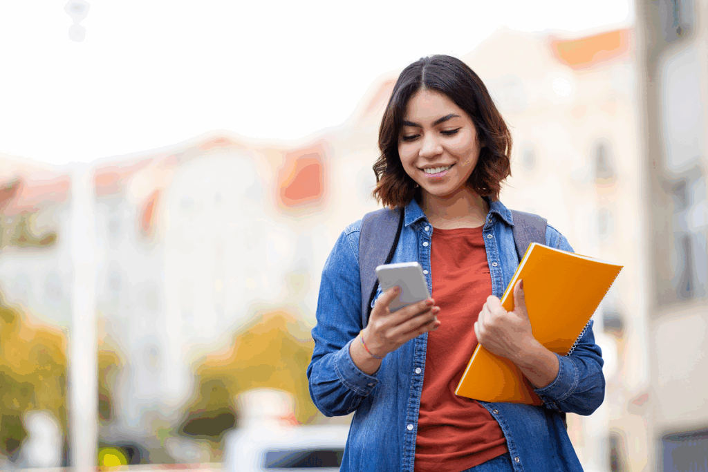 Menina estudante checando o celular. Quantos pontos precisa para passar em medicina no enem.