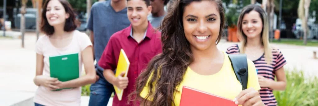 aluna sorridente com colegas ao fundo