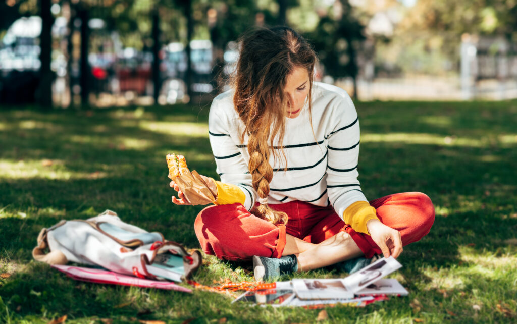 Mulher jovem estudando nas férias escolares em um parque. 