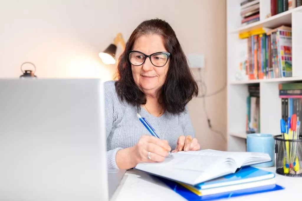 mulher estudando com livros e computador